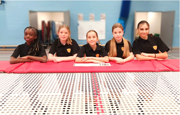 A group of girls sitting at a table

Description automatically generated