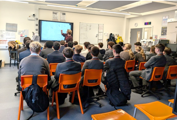 A group of people sitting in chairs in a classroom

Description automatically generated