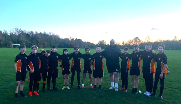 A group of boys in uniform standing on a field

Description automatically generated