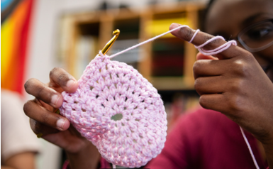 A person knitting a pink object

AI-generated content may be incorrect.