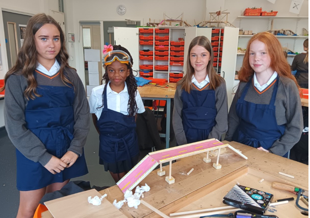 A group of girls in uniform standing in front of a table
AI-generated content may be incorrect.