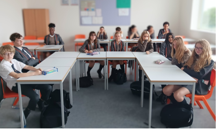 A group of students sitting in a classroom

AI-generated content may be incorrect.