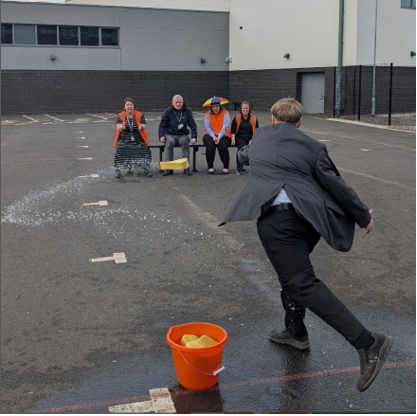A person throwing water into a group of people

AI-generated content may be incorrect.