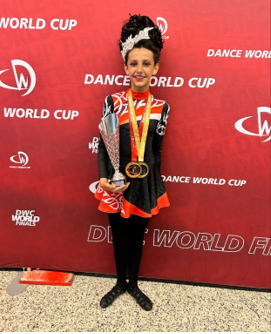 A child in a cheerleader garment holding a trophy
AI-generated content may be incorrect.