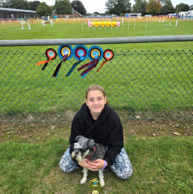 A child sitting on the ground holding a dog
AI-generated content may be incorrect.